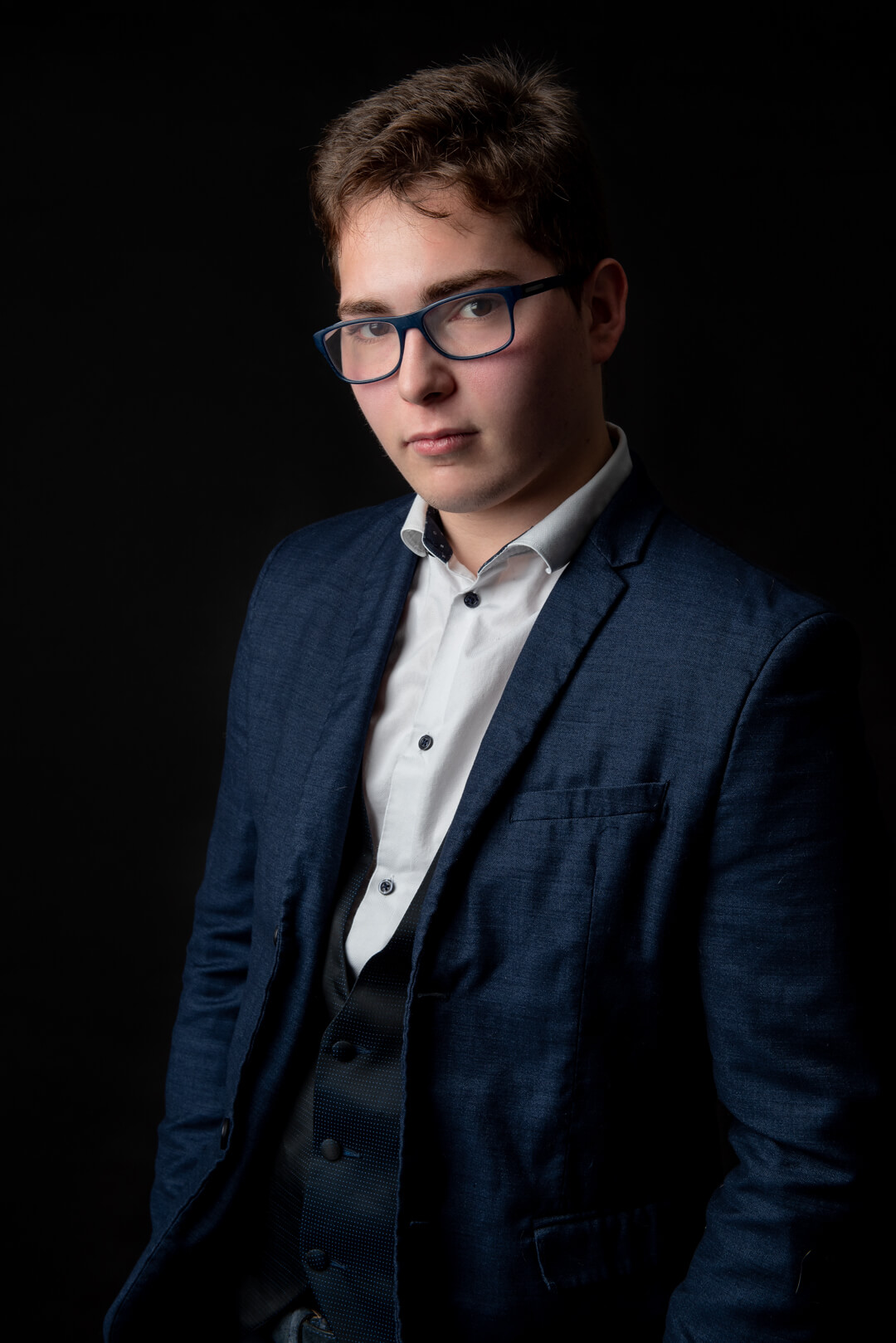 photo d'un jeune homme sur fond noir sans reflets de lunettes