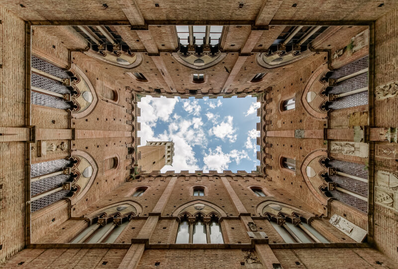 cour intérieure d'un bâtiment photographié en perspective à un seul point de fuite, symétrique de tous les côtés ou presque