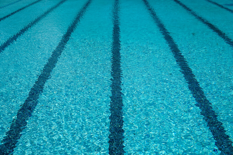 gros plan de l'eau d'une piscine avec les lignes au fond qui créent la symétrie