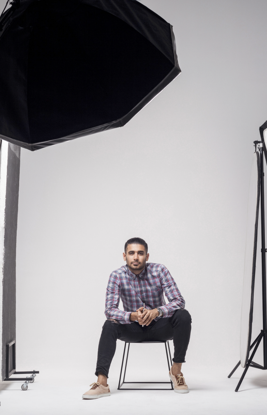 Homme assis dans un studio de photo éclairé par un softbox octogonal